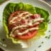 Keto BLT lettuce wraps on white plate with crispy bacon, fresh tomatoes, and butter lettuce cups drizzled with herb mayo